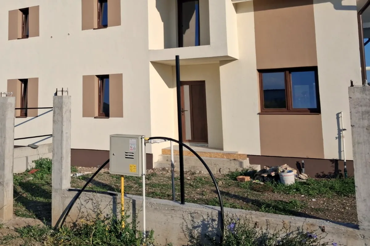 Structură de beton pentru gard, cu stâlpii turnați, în fața unei case